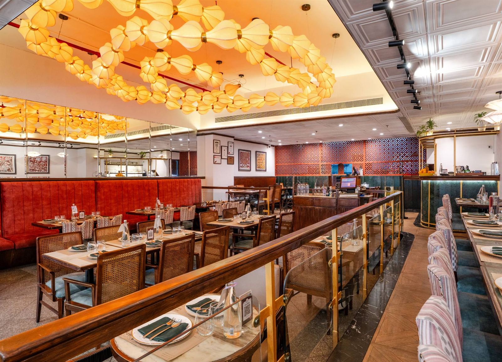 Sattvik at Saket, under a ceiling of glowing paper lanterns with red velvet banquettes and cane chairs