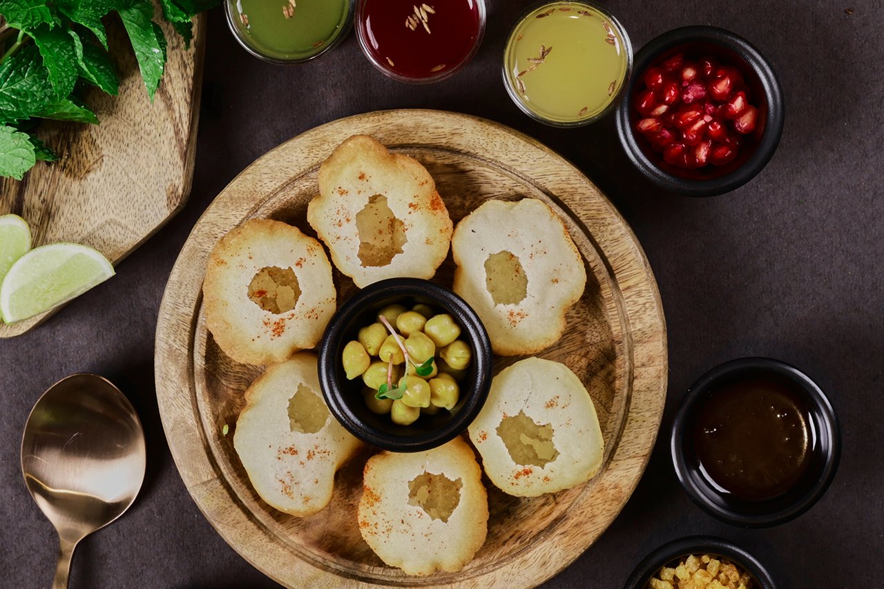 Gol gappe with fillings and dips on a wooden board