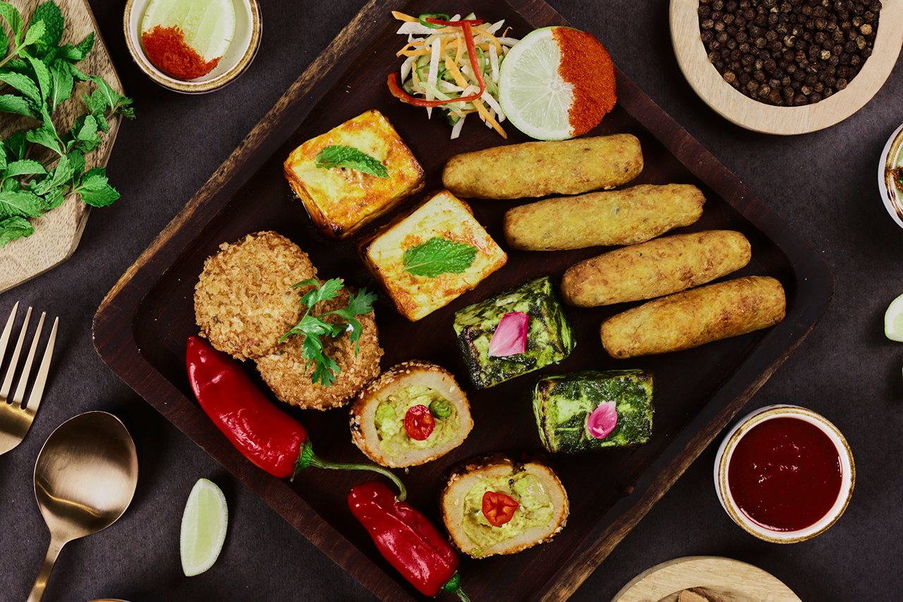 A platter of tandoori starters and kebabs on black slate