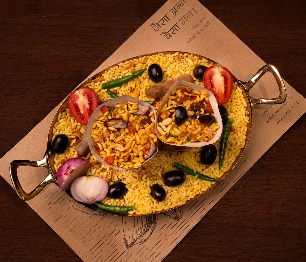 Bhel served in paper cones on puffed rice in a copper pan