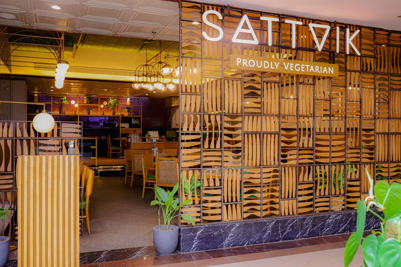 The Sattvik entrance with its Proudly Vegetarian sign, wooden lattice screen and the dining room beyond